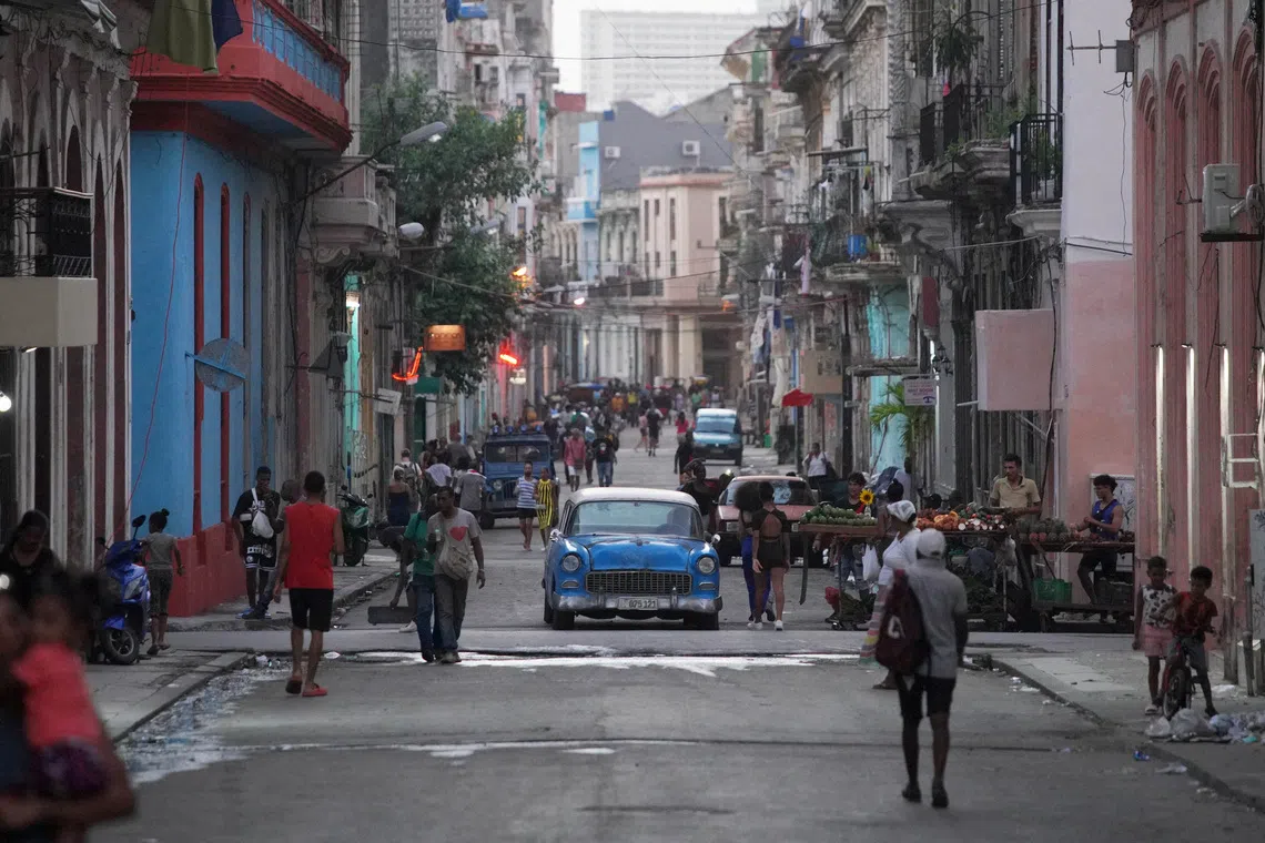 FILE PHOTO: People walk on the street in downtown Havana, Cuba, November 21, 2023. REUTERS/Alexandre Meneghini/File Photo