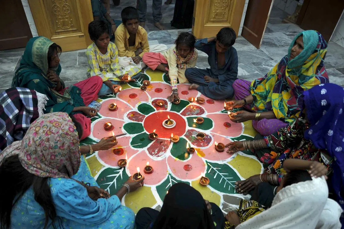 Pakistani Hindus lighting earthen lamps to celebrate the Diwali festival in Hyderabad, Pakistan on Nov 12, 2023. 