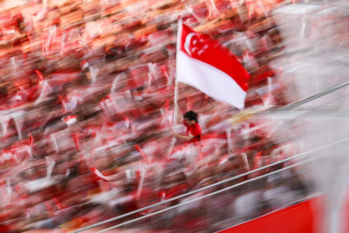 The state flag begins its ceremonial relay, symbolising unity and the nation's shared journey, during National Day Parade 2026 at the National Stadium on Aug 9, 2026. ST PHOTO: BRIAN TEO