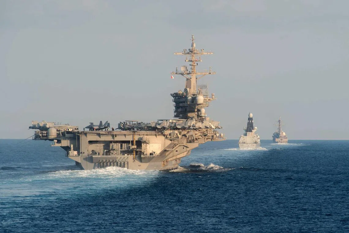 (FILES) (L-R) The aircraft carrier USS Abraham Lincoln (L), the air-defense destroyer HMS Defender and the guided-missile destroyer USS Farragut transit the Strait of Hormuz on November 19, 2019. The US will bolster its military presence in the Middle East, deploying additional warships and fighter jets to protect US personnel and defend Israel amid soaring tensions in the region, the Pentagon said on August 2, 2024. The aircraft carrier strike group led by the USS Abraham Lincoln will replace one helmed by the USS Theodore Roosevelt in the region, deputy Pentagon Press Secretary Sabrina Singh said. (Photo by Zachary PEARSON / US NAVY / AFP) / RESTRICTED TO EDITORIAL USE - MANDATORY CREDIT "AFP PHOTO /  US NAVY/Mass Communication Specialist 3rd Class Zachary Pearson" - NO MARKETING NO ADVERTISING CAMPAIGNS - DISTRIBUTED AS A SERVICE TO CLIENTS