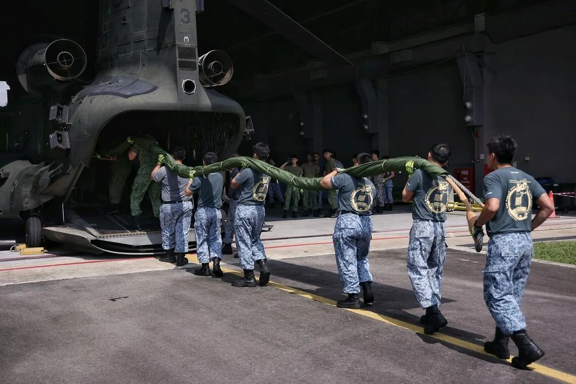 The flag party loading the state flag up the CH-47 Chinook heavy lift helicopter before the flight to Pulau Sudong from Sembawang Airbase on July 4.