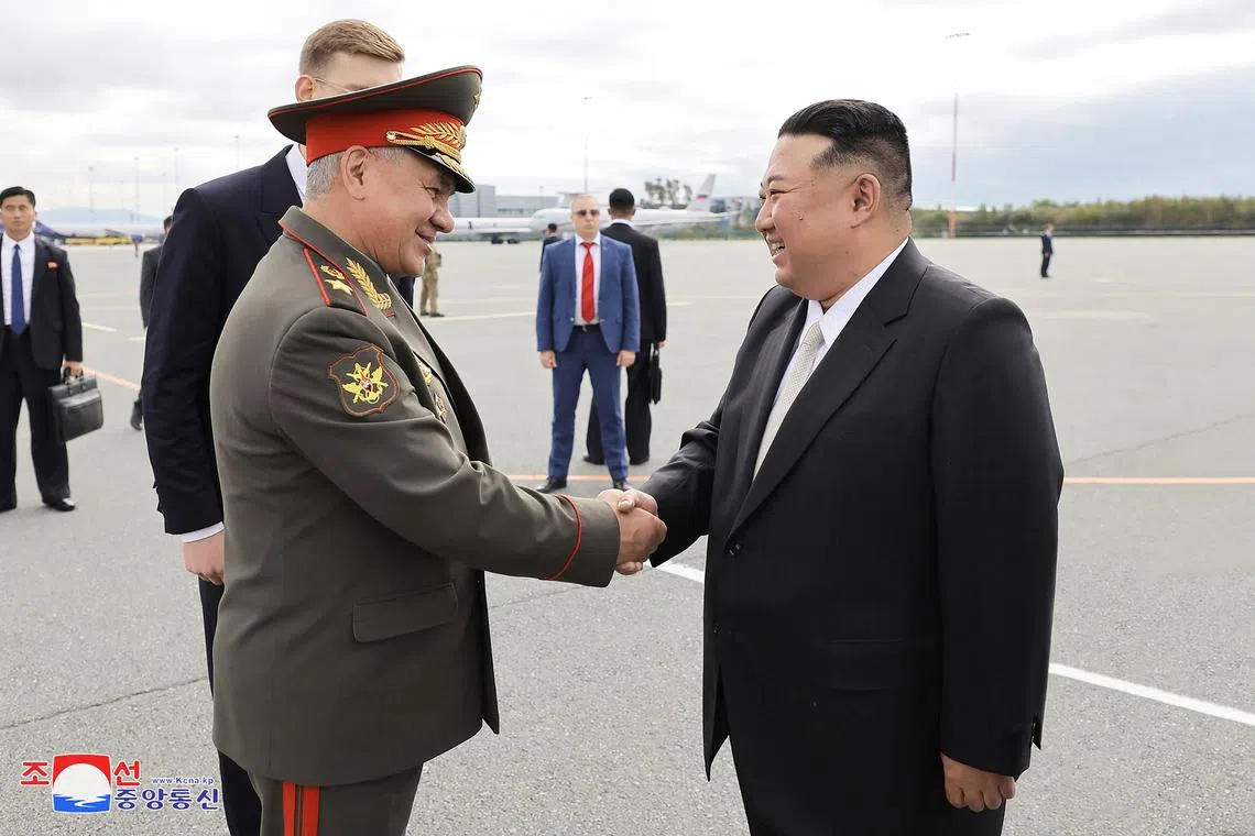 North Korea's leader Kim Jong Un (right) shaking hands with Russia's Defence Minister Sergei Shoigu at the Knevichi airfield.