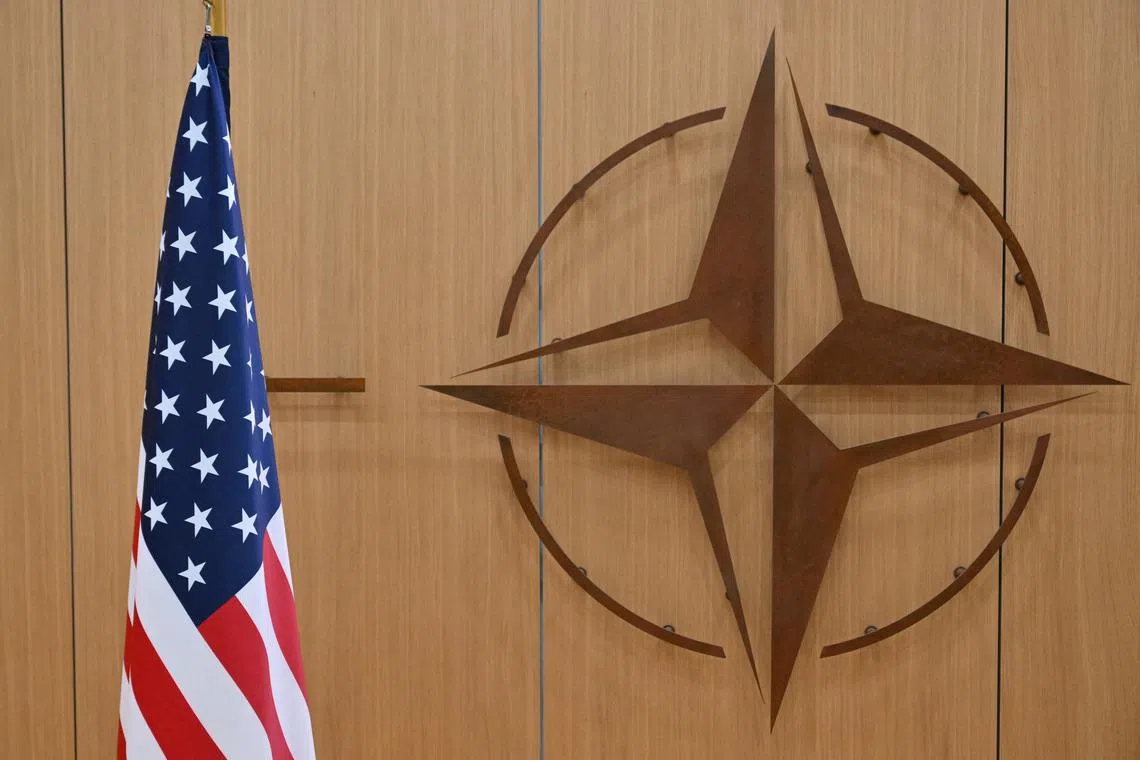 FILE PHOTO: The logo of the North Atlantic Treaty Organisation (NATO) and the US flag at NATO headquarters in Brussels, Belgium on February 17, 2025. NICOLAS TUCAT/Pool via REUTERS/File Photo