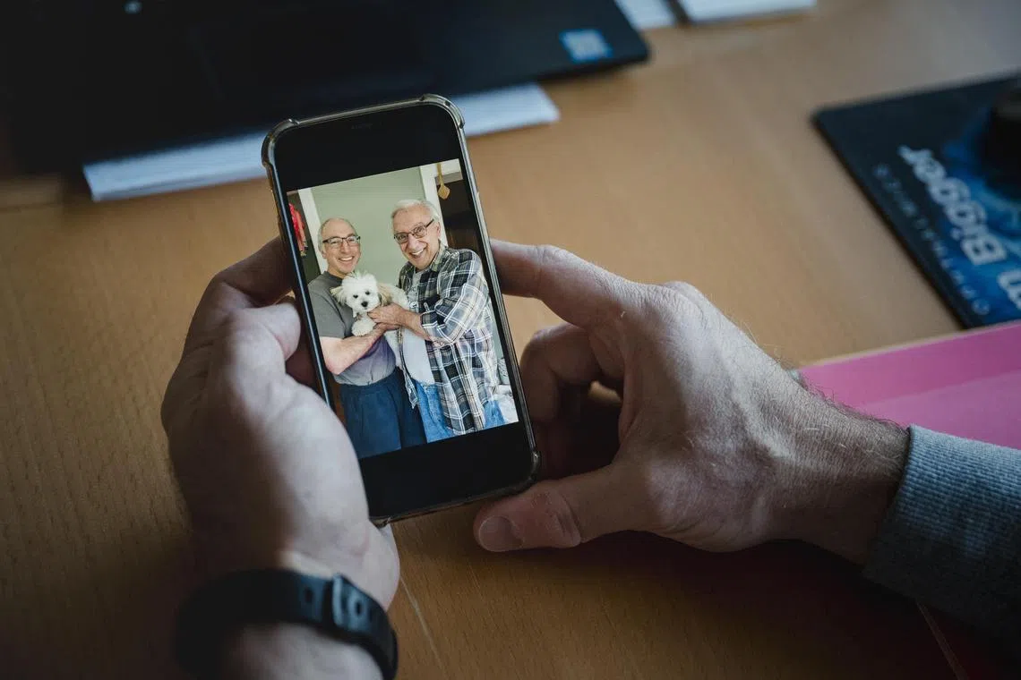 Mr Chris Mancinelli, at his home in Collegeville, Pennsylvania, looks at a 2021 photograph of him with his father, Alfred, who died in 2023, .