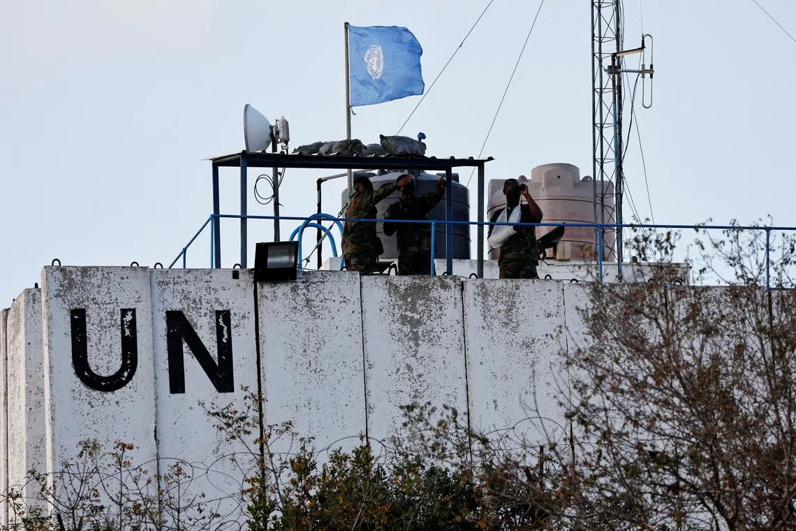 FILE PHOTO: Members of the United Nations peacekeepers (UNIFIL) look at the Lebanese-Israeli border, as they stand on the roof of a watch tower ‏in the town of Marwahin, in southern Lebanon, October 12, 2023. REUTERS/Thaier Al-Sudani/File Photo