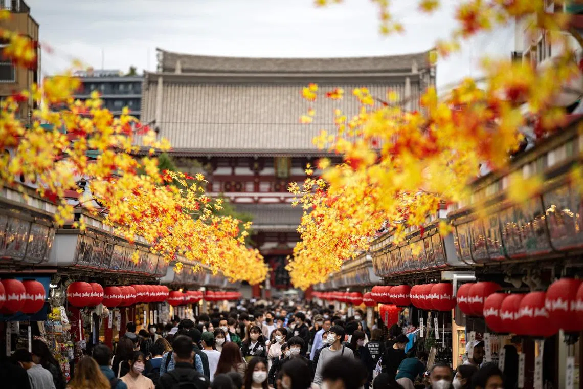 (FILES) In this file photo taken on October 12, 2022 people visit Sensoji Temple, a popular tourist location, in Tokyo. - Travellers returning to China from January 8, 2023 will no longer have to quarantine, removing one of the main barriers to travel for the country's population, and sparking a frenzy of trip planning for thousands ready to return to top Asian tourist spots. (Photo by Philip FONG / AFP)
