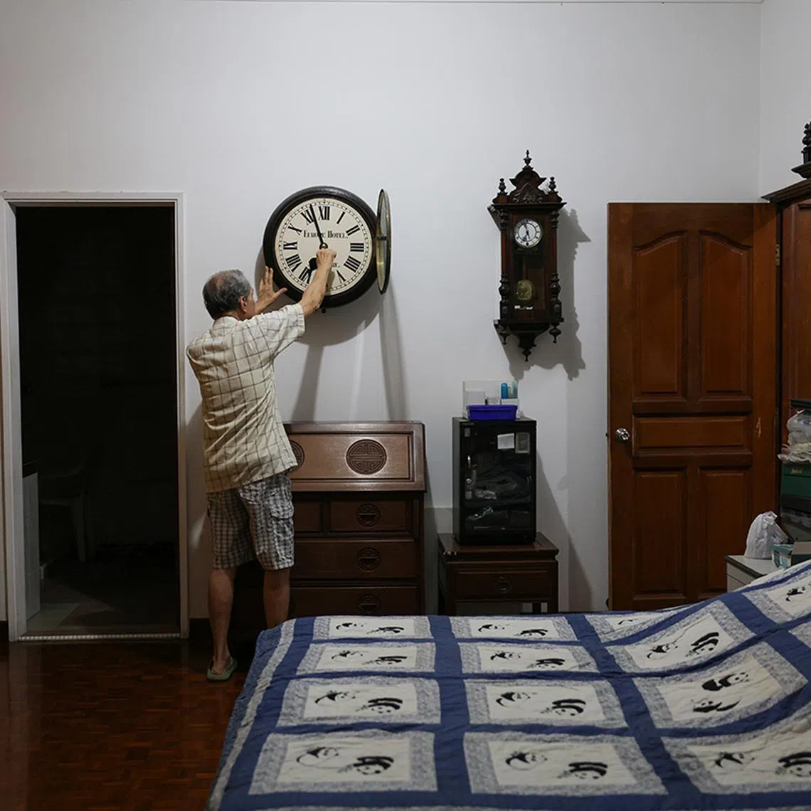 ST20240407_202415406861: Gin Tay/ gtclock/Ang Qing/  Mr Mun Chor Weng, 83, winding The Europe Hotel Clock in his bedroom on every Sunday morning between 6.30 am to 7am. Mr Mun has a Sunday winding habit that can be traced to his teenage years helping his dad to wind up all the clocks in the shop. Most if not all the clocks in the shop run for 7 days. Even after Mr Mun relocated with the clocks, he continued with the Sunday ritual and made it a point to wind the clock when he wakes up around 6.30 to 7am.