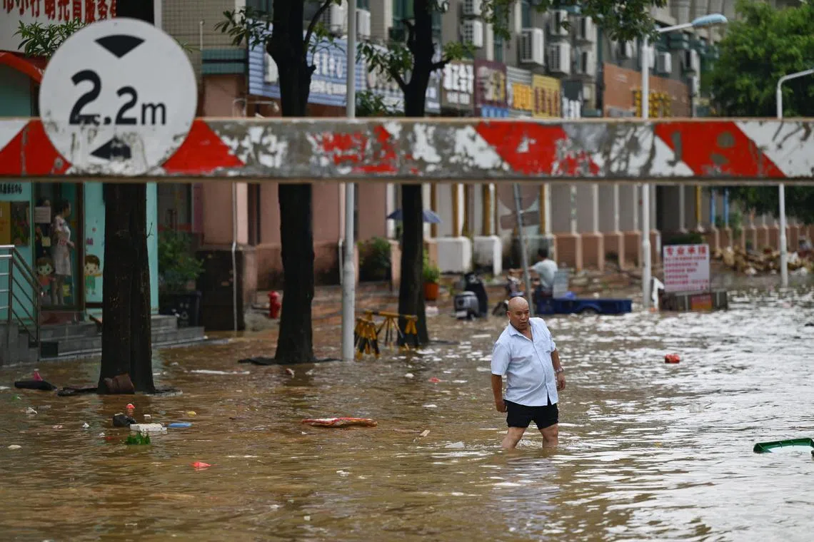 A man walks through a flooded street in Zhongshan, in China's southern Guangdong province on June 17, 2025. 
