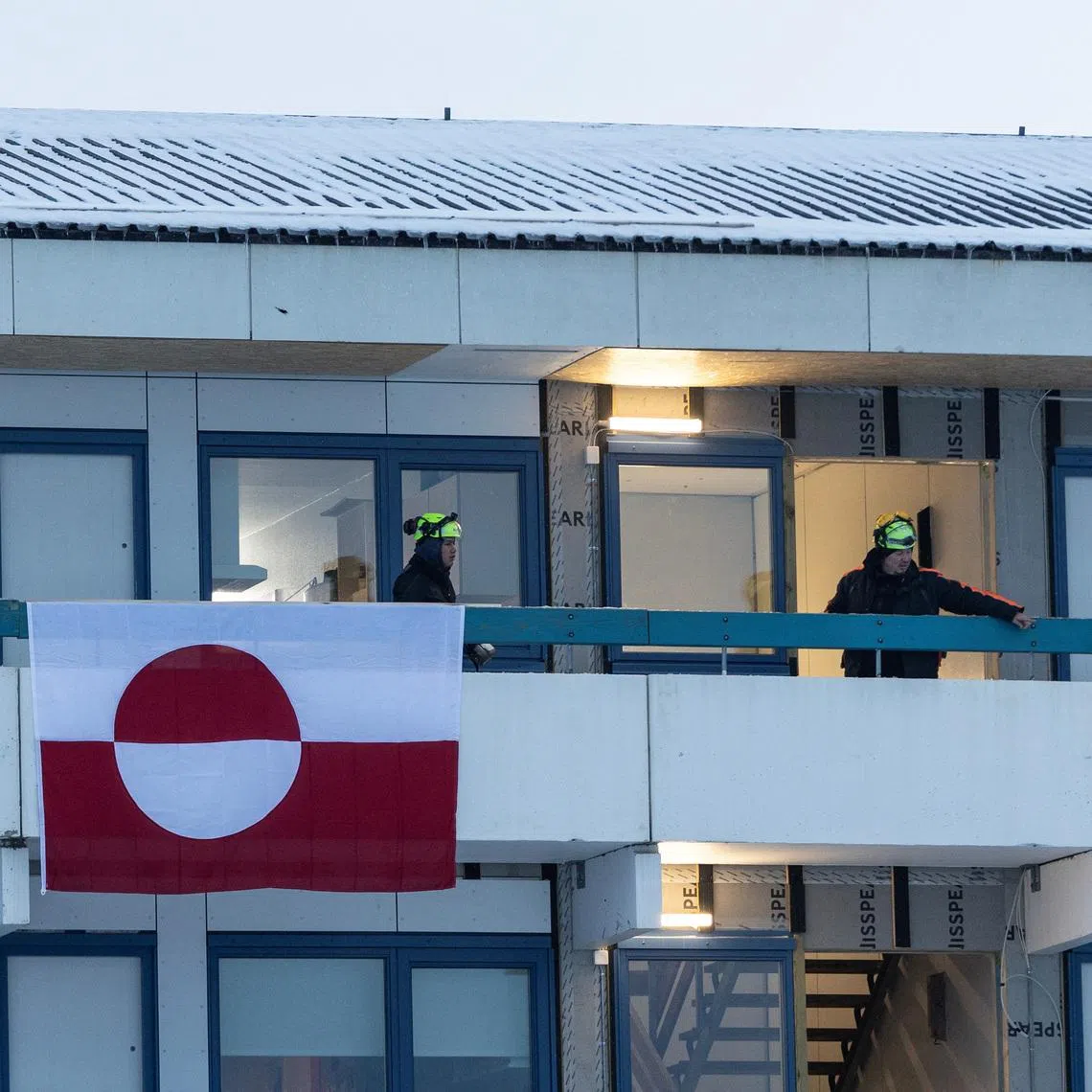 Construction workers stand on a terrace of a residential building in Nuuk, Greenland, January 14, 2026. REUTERS/Marko Djurica