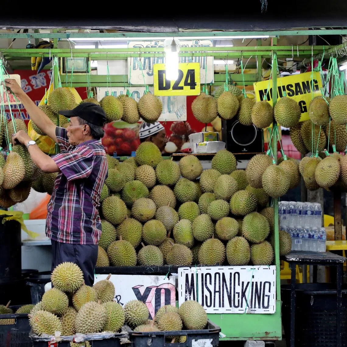 A man arranges durians at a market stall in Kuala Lumpur, Malaysia, in 2019.