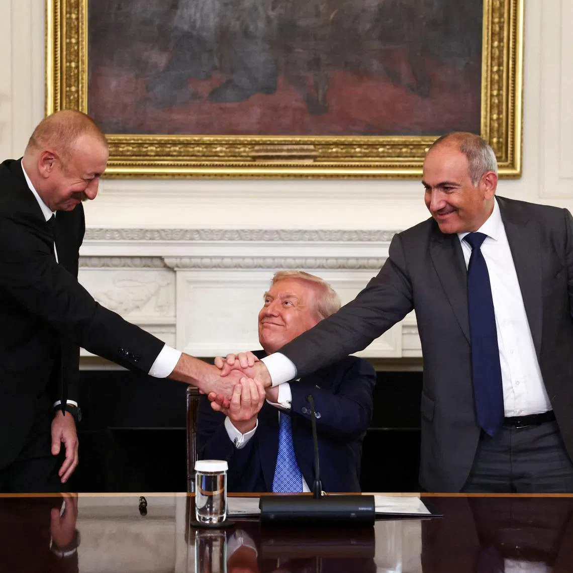 FILE PHOTO: U.S. President Donald Trump holds the hands of Azerbaijan's President Ilham Aliyev and Armenia's Prime Minister Nikol Pashinyan as they shake hands between each other during a trilateral signing event, at the White House, in Washington, D.C., August 8, 2025. REUTERS/Kevin Lamarque/File Photo
