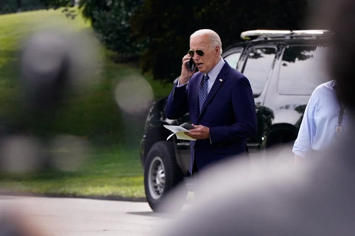 U.S. President Joe Biden talks on a phone while walking towards Marine One as he departs the White House in Washington, U.S., August 16, 2024. REUTERS/Elizabeth Frantz/File Photo