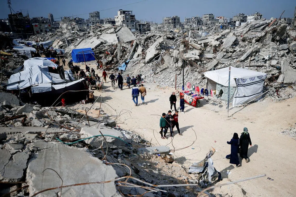 FILE PHOTO: Palestinians walk on a street among the rubble of buildings destroyed during the Israeli offensive, amid a ceasefire between Israel and Hamas, at Jabalia refugee camp, northern Gaza Strip, February 17, 2025. REUTERS/Mahmoud Issa/File Photo