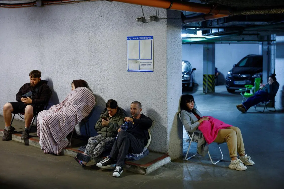 Residents take shelter inside an underground parking during Russian missile and drone strikes in Kyiv on June 15.