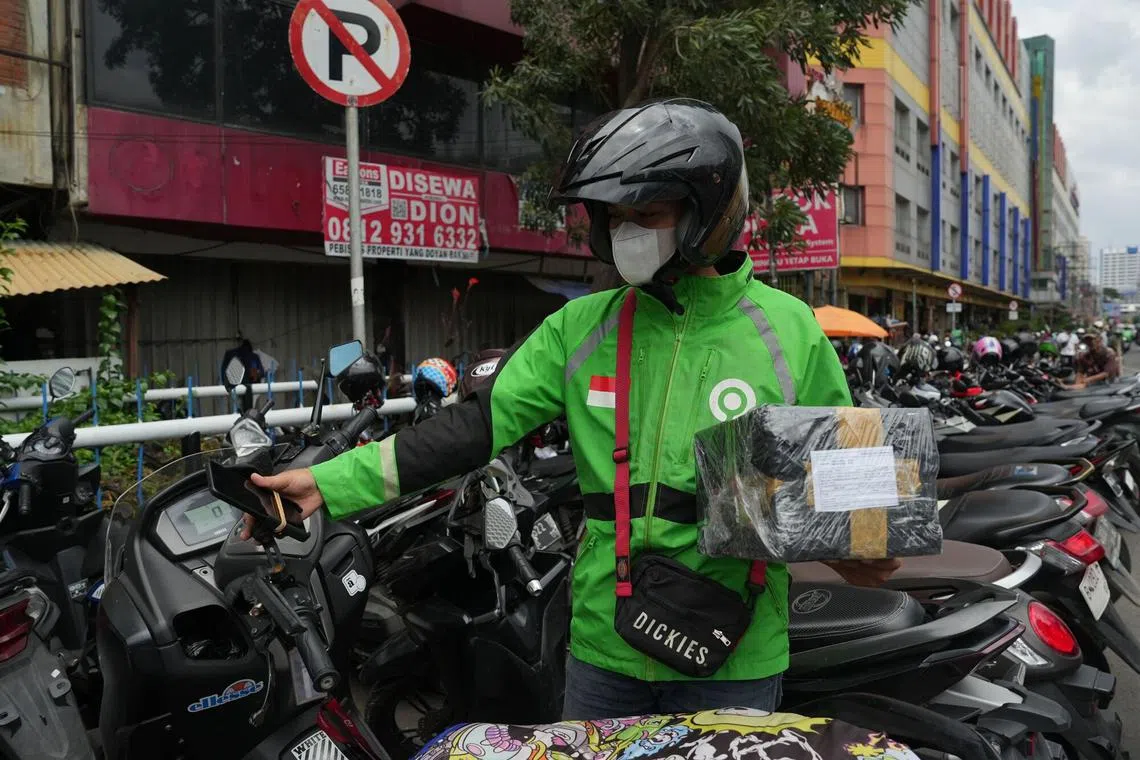 A Gojek driver looks at a smartphone in Jakarta, Indonesia, on Monday, March 18, 2024. PT GoTo Gojek Tokopedia will announce its earnings on March 19. Photographer: Dimas Ardian/Bloomberg