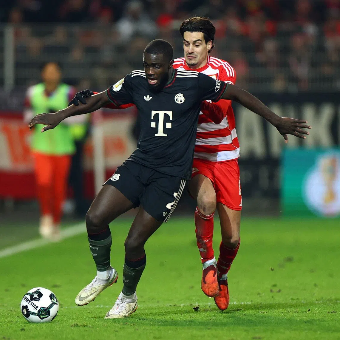Soccer Football - DFB Cup - Round of 16 - 1. FC Union Berlin v Bayern Munich - Stadion An der Alten Forsterei, Berlin, Germany - December 3, 2025 Bayern Munich's Dayot Upamecano in action with 1. FC Union Berlin's Diogo Leite REUTERS/Lisi Niesner