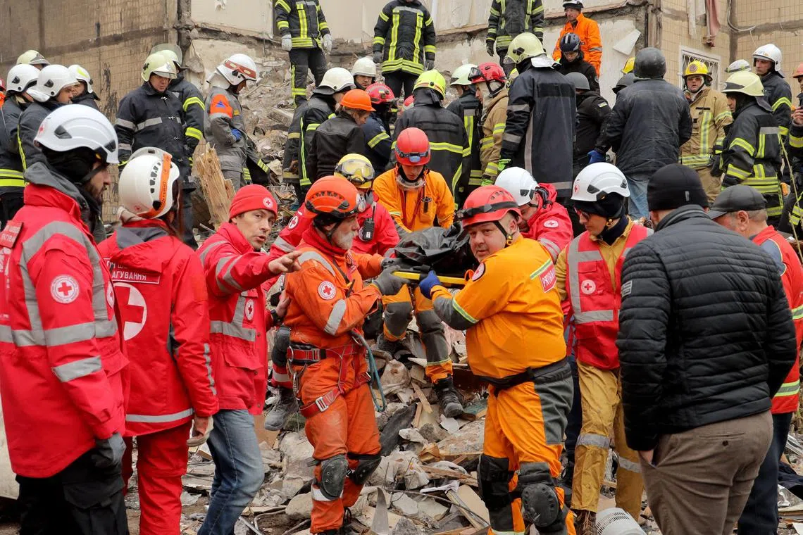 Rescuers carry a body at the site of a Russian drone attack on an apartment building in Odesa, Ukraine.