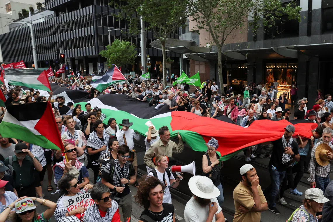 Demonstrators hold a large Palestinian flag during the 'Nationwide March for Palestine', after a ceasefire between Israel and Hamas in Gaza went into effect, in Sydney, Australia, October 12, 2025. REUTERS/Hollie Adams