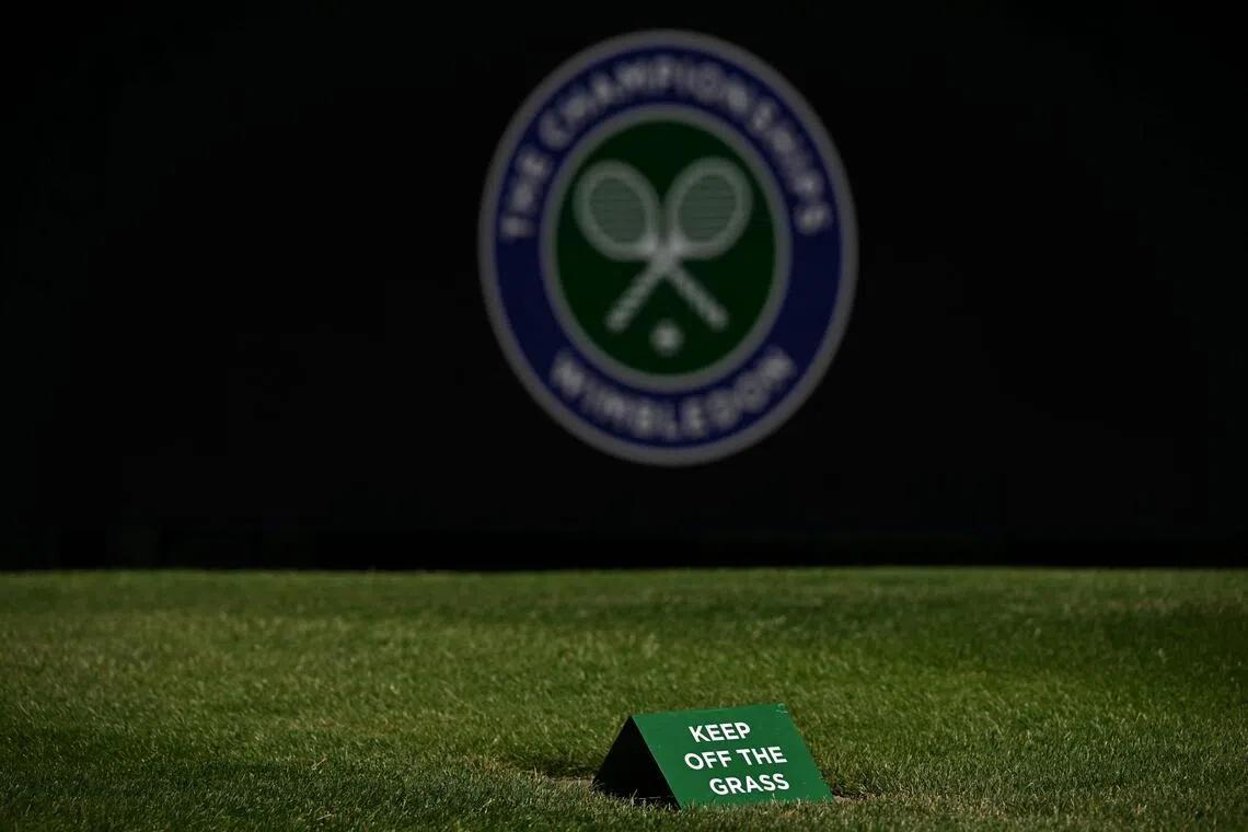 A keep of the grass sign is pictured on a court at The All England Lawn Tennis and Croquet Club in Wimbledon, southwest London, on June 24, 2026, ahead of the 2026 Wimbledon Championships. (Photo by Glyn KIRK / AFP) / RESTRICTED TO EDITORIAL USE