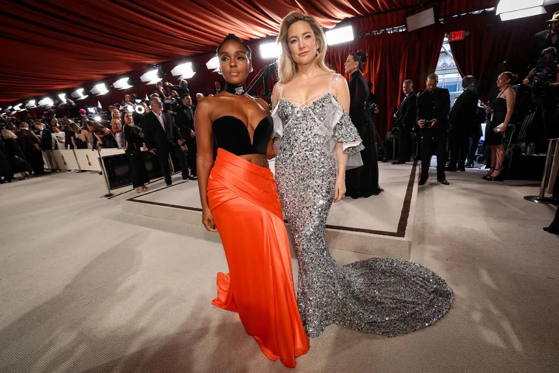 Janelle Monae and Kate Hudson pose on the champagne-colored red carpet during the Oscars arrivals at the 95th Academy Awards.
