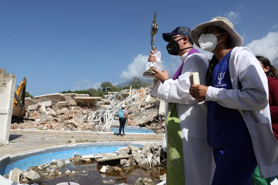 A priest holds a monstrance at the site of a collapsed buildng in the aftermath of the June 24 earthquakes in La Guaira, Venezuela, July 1, 2026. REUTERS/Ricardo Arduengo