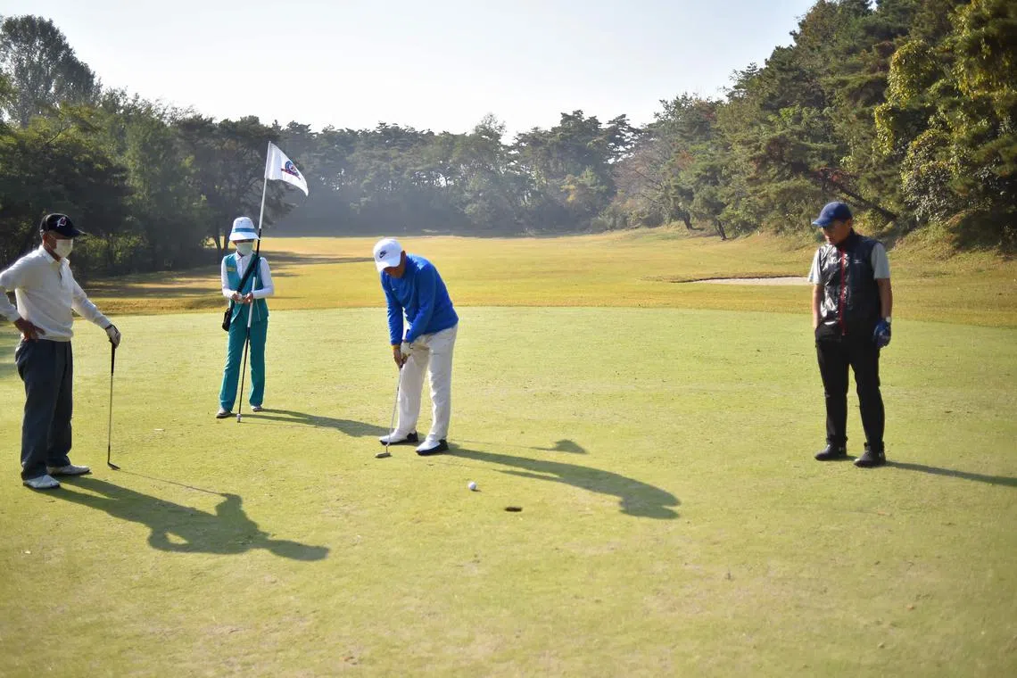 (FILES) In this photo taken on October 20, 2022, a contestant putts the ball during an autumn golf contest at the Pyongyang Golf Course in Nampho City. North Korea on August 2023 has invited foreign golfers to a tournament in Pyongyang, another possible sign of the reclusive country's reopening after Chinese and Russian officials attended a military parade last month. (Photo by KIM Won Jin / AFP)