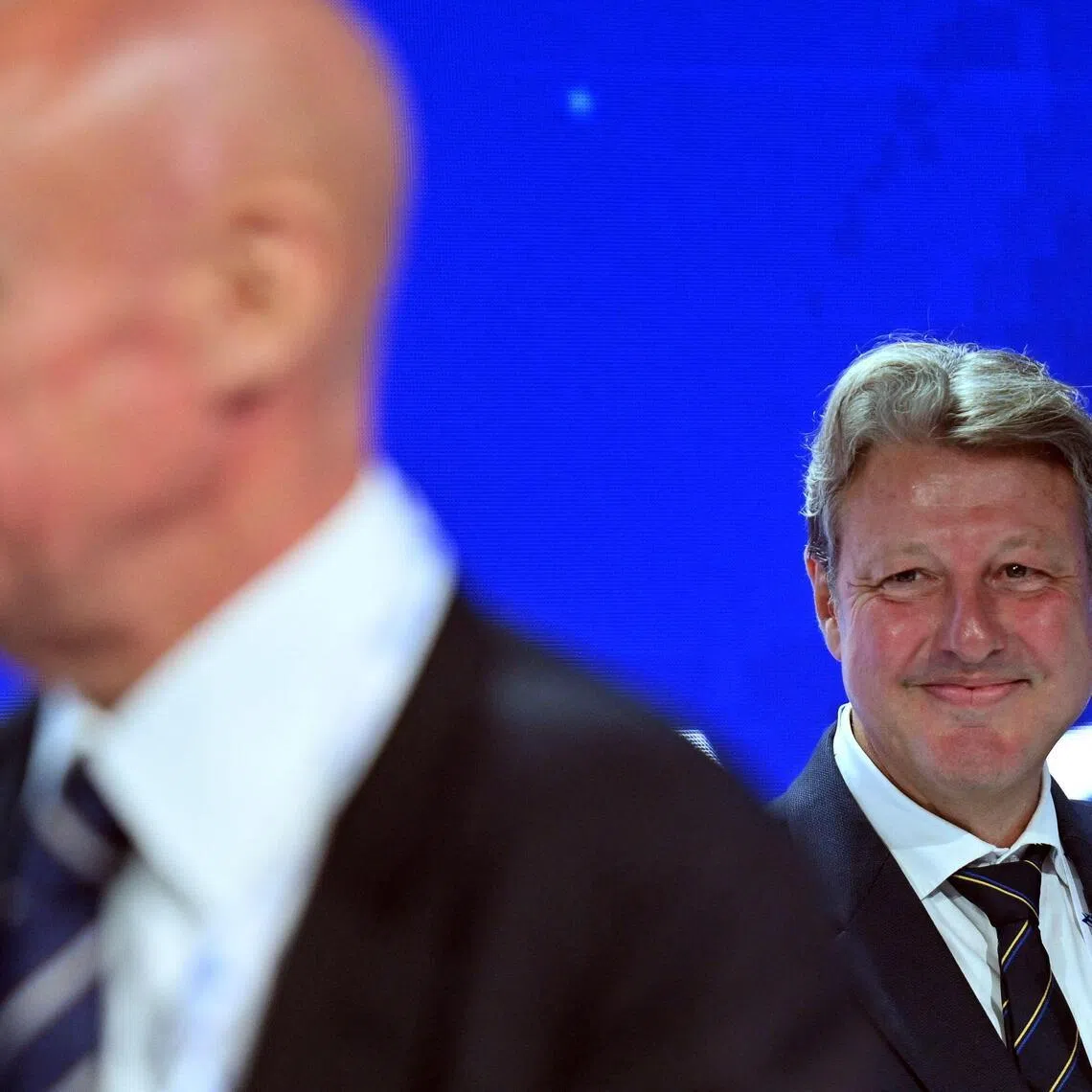 Newly elected president of the International Ski and Snowboard Federation (FIS), Alexander Ospelt, looks on next to former chief Johan Eliasch after the vote at the 57th International FIS Congress 2026 in Belgrade, Serbia, on June 11, 2026.