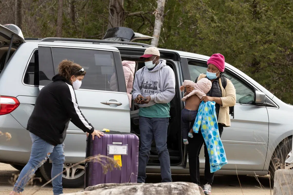 FILE PHOTO: A group of asylum seekers claiming to be from Haiti take their luggage out of a taxi as they arrive near a checkpoint on Roxham Road near Hemmingford, Quebec, Canada April 24, 2022. Picture taken April 24, 2022. REUTERS/Christinne Muschi/File Photo