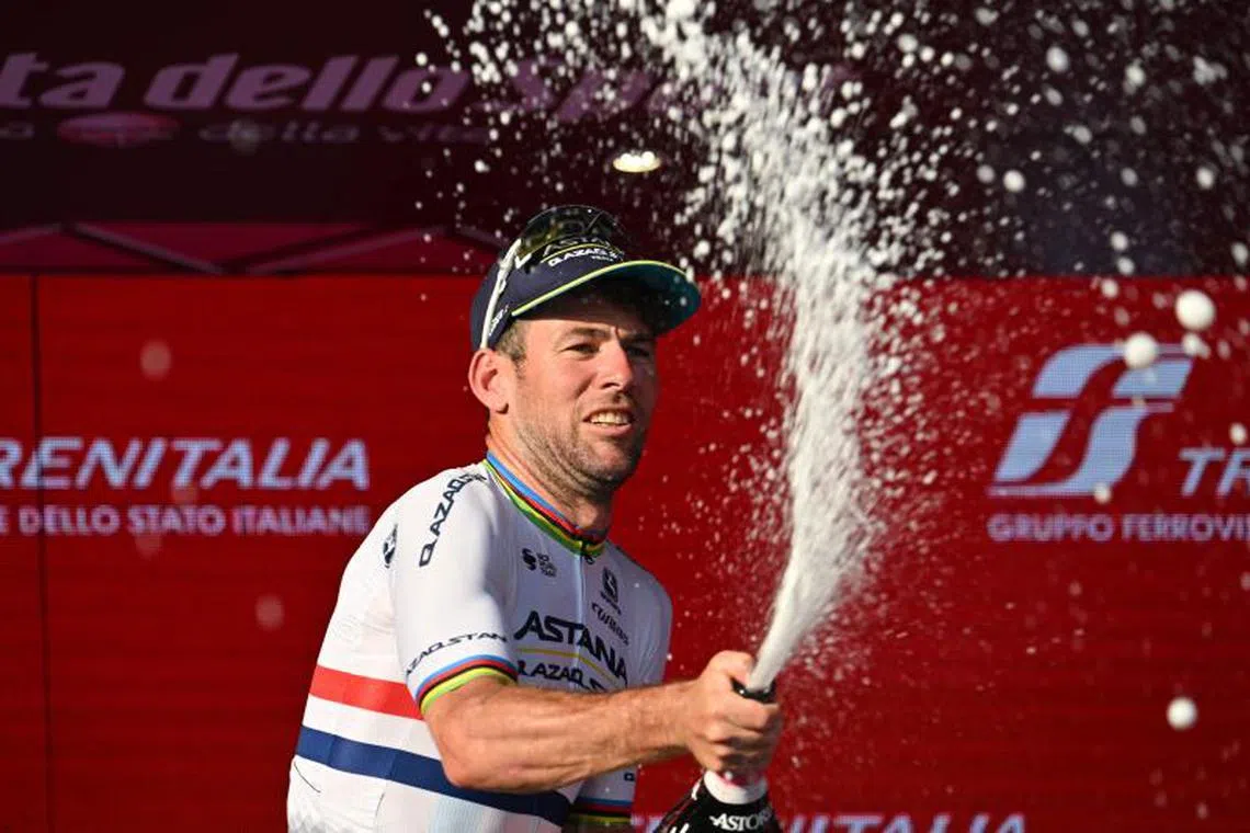 (FILES) Astana Qazaqstan Team's British rider Mark Cavendish sprays sparkling wine as he celebrates on the podium after winning the twenty-first and last stage of the Giro d'Italia 2023 cycling race, 135 km in and around Rome on May 28, 2023. Cycling great Mark Cavendish announced his retirement from the sport on November 9, 2024, writing on social media that his final race will be Sunday's Tour de France Singapore Criterium. "Sunday will be the final race of my professional cycling career," wrote the 39-year-old British sprint legend, the record stage winner on the Tour de France with 35, in a post on Instagram. (Photo by Alberto PIZZOLI / AFP)
