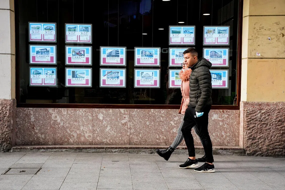 FILE PHOTO: Young people walk past an estate agent in Guernica, Spain, January 18, 2022. REUTERS/Vincent West/File Photo