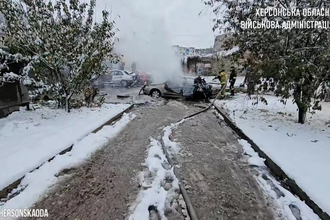First responders work near burnt-out cars after a reported deadly Russian artillery strike in Kherson, Ukraine, in this still image from handout video released November 20, 2023. Kherson Regional State Administration/Handout via REUTERS