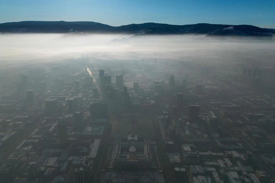 TOPSHOT - An aerial view shows thick smog from air pollution shrouding Ulaanbaatar, the capital of Mongolia, on December 16, 2024. (Photo by Byambasuren BYAMBA-OCHIR / AFP)