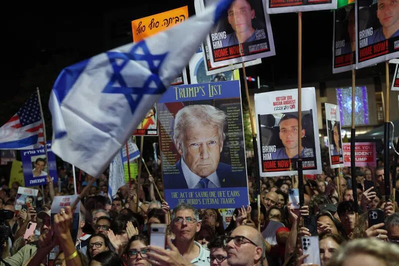 People wave Israeli and US flags during a gathering at Hostages Square in Tel Aviv on Oct 11, 2025.