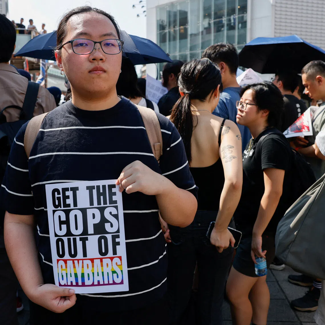 A protestor holding a sign as people march and protest after the police raided a gay bar ahead of the annual Taiwan Pride parade, in Taipei, on Oct 4.