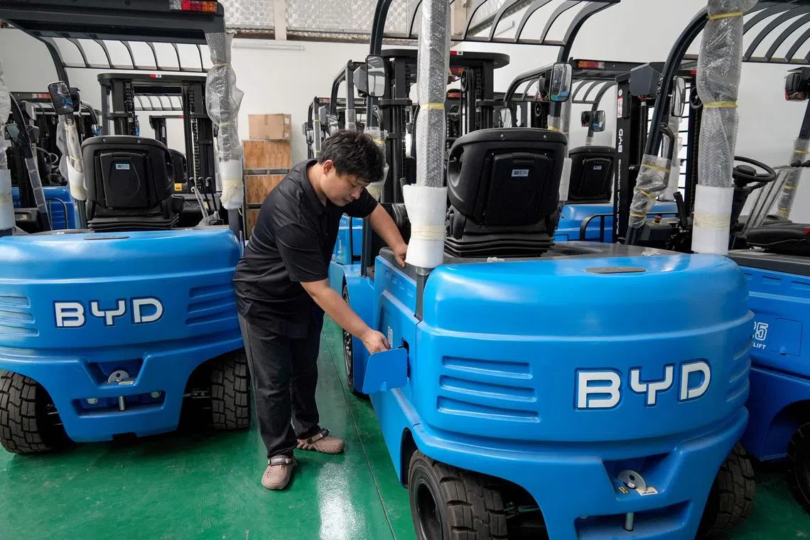 Mr Zhang Chundong, manager at Huochacha New Energy Group, inspecting a forklift at his factory in Bac Ninh province in Vietnam. 