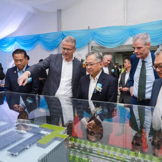 DPM Gan Kim Yong with EDB chairman Png Cheong Boon (2nd from left) and AP Moller-Maersk chief executive Vincent Clerc (3rd from left), looking at a model of World Gateway II, a $200 million facility designed to help companies store and ship goods.