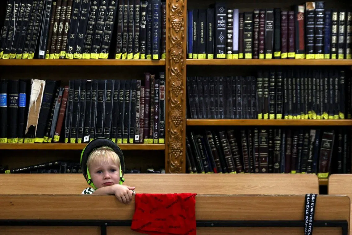 A child sitting inside a bomb shelter, which was used as a synagogue and is now used as a full-time accommodation by an Israeli family since the start of the Iran-Israel conflict, in Haifa, Israel, June 19, 2025. 