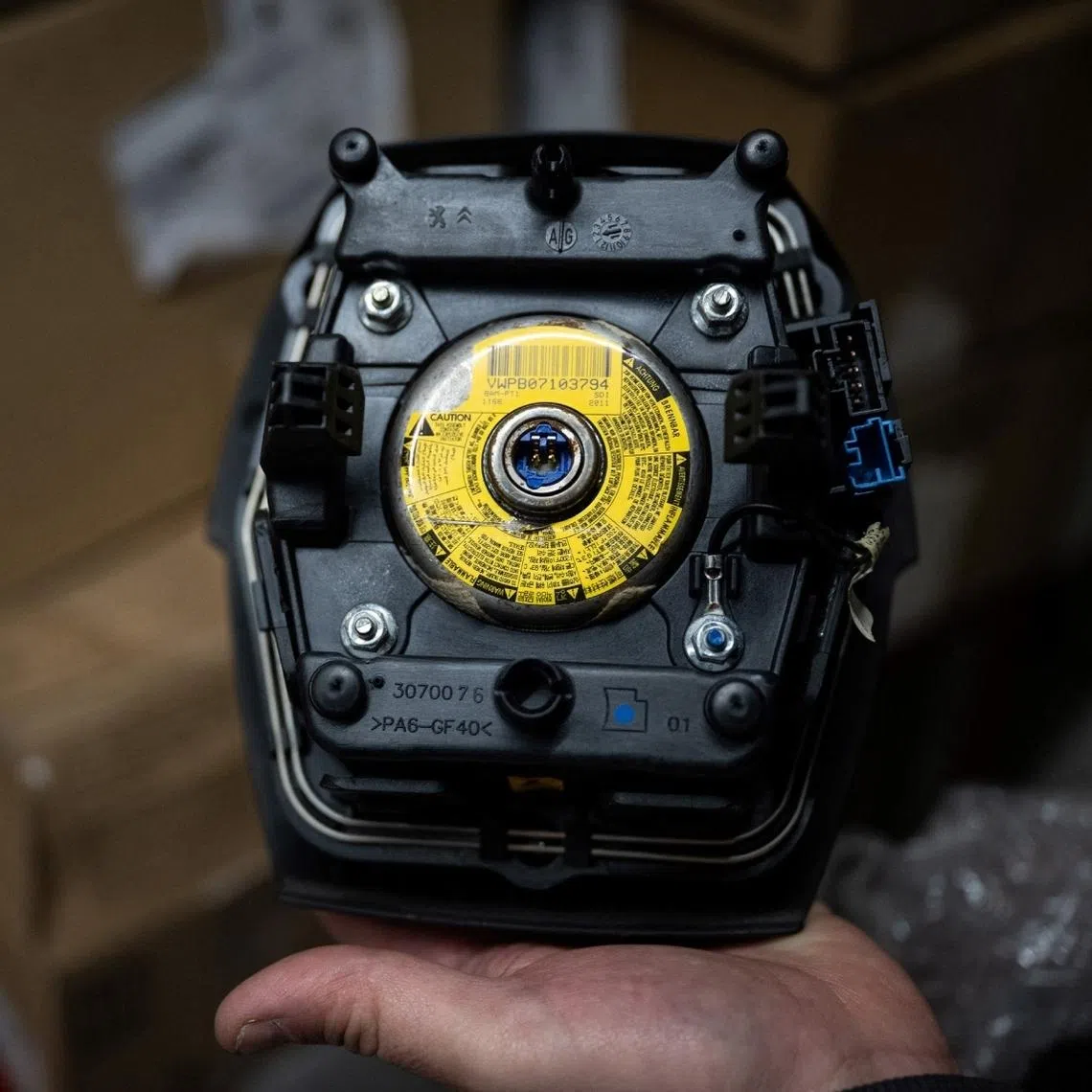 A mechanic holds an airbag module made by the Japanese airbag manufacturer Takata.