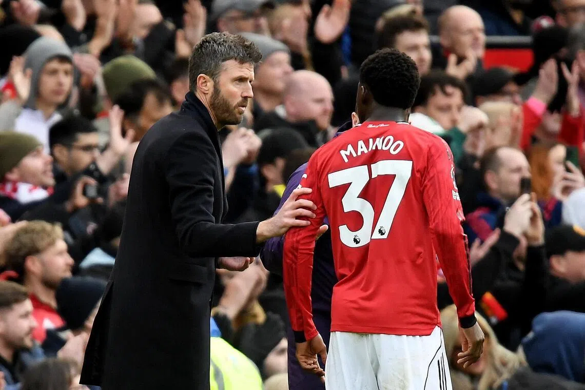 Manchester United interim manager Michael Carrick speaks to Kobbie Mainoo during a Premier League match against Aston Villa.