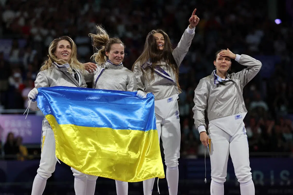 Paris 2024 Olympics - Fencing - Women's Sabre Team Gold Medal Match - Grand Palais, Paris, France - August 03, 2024. Olga Kharlan of Ukraine, Alina Komashchuk of Ukraine, Olena Kravatska of Ukraine, Yuliia Bakastova of Ukraine celebrate after winning the Gold medal. REUTERS/Maye-E Wong
