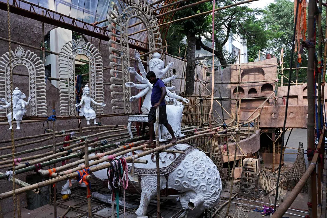 A worker walking through a temporary pandal under construction, ahead of the Durga Puja festival in Kolkata, India on Sept 9, 2025.
