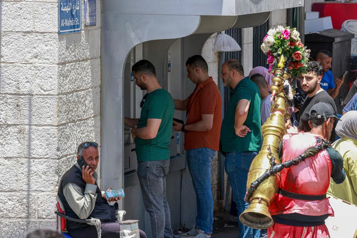 Palestinians queue to withdraw money from an ATM in the main market in Ramallah city in the Israel-occupied West Bank on June 9. Since the start of the war in Gaza triggered by the unprecedented Hamas attack in Israel on Oct 7, the financial situation of the Palestinian Authority has continued to deteriorate, mainly due to Israeli restrictions imposed on the transfer of tax revenues. 