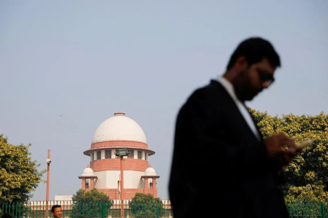 FILE PHOTO: A lawyer looks into his mobile phone in front India's Supreme Court in New Delhi, December 11, 2023. REUTERS/Adnan Abidi/File Photo