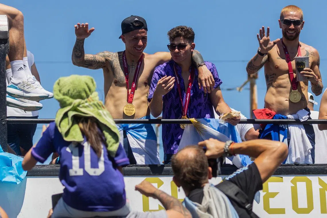 Argentina's Enzo Fernandez (L), Julian Alvarez (C) and Alejandro Gomez (R) wave to supporters, Dec 20, 2022.  