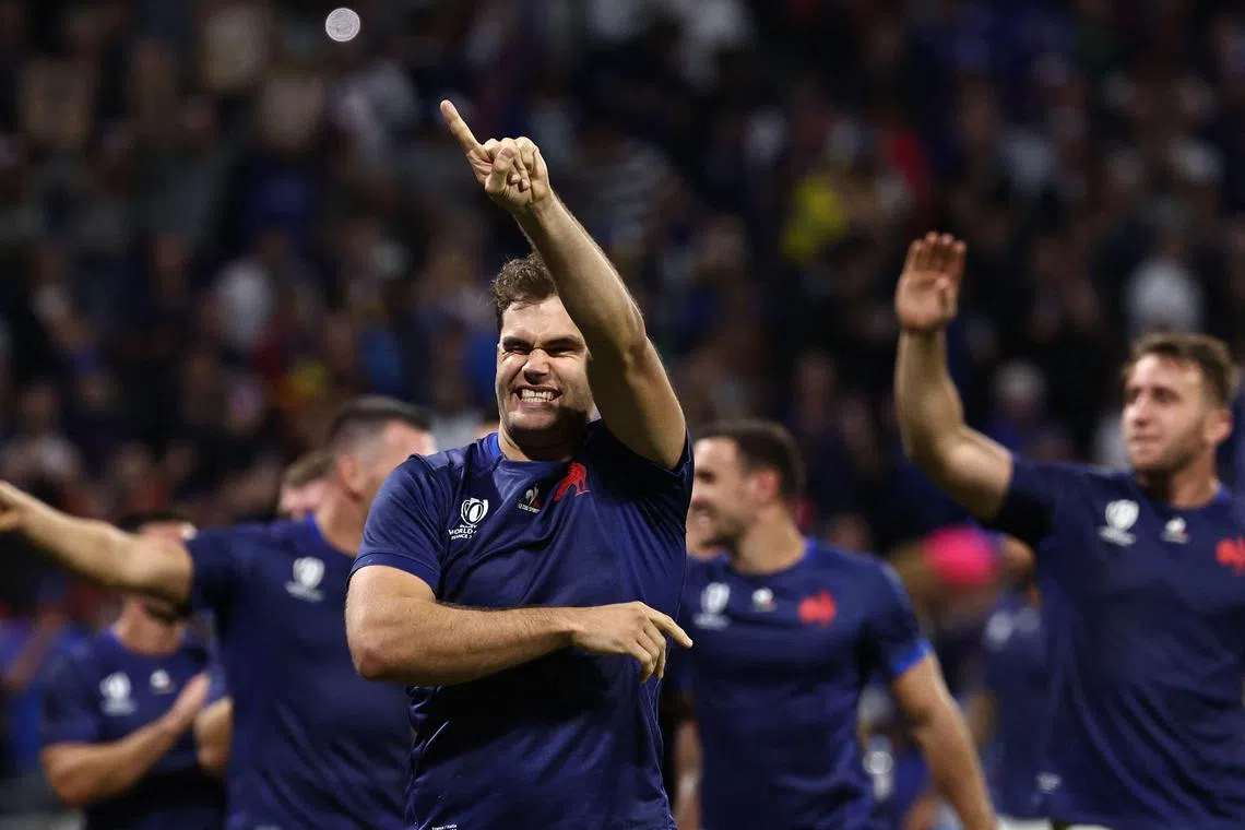 France's right wing Damian Penaud (left) gestures to the crowd as he celebrates France's win against Italy.