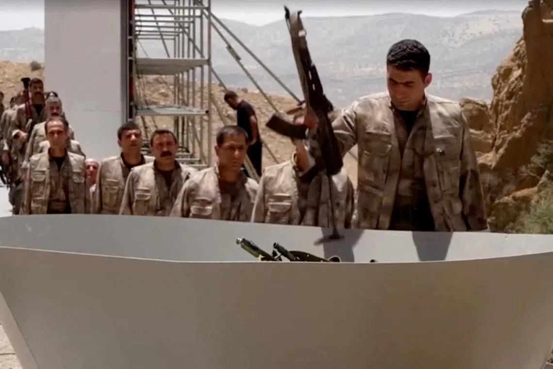 FILE PHOTO: An armed PKK fighter places a weapon to be burnt during a disarming ceremony in Sulaimaniya, Iraq, July 11, 2025, in this screengrab obtained from a handout video. KURDISTAN WORKERS PARTY MEDIA OFFICE/Handout via REUTERS/File Photo