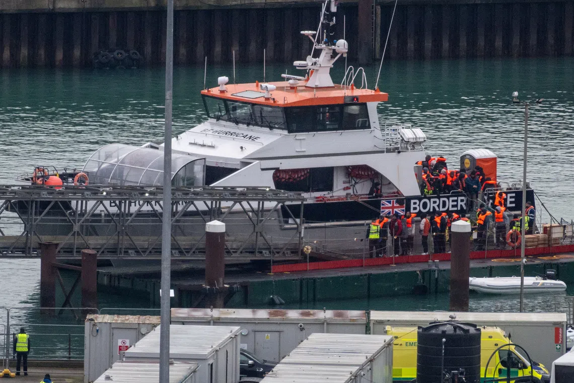 FILE PHOTO: People, believed to be migrants, disembark from a British Border Force vessel as they arrive at the Port of Dover, in Dover, Britain, December 29, 2024. REUTERS/Chris J. Ratcliffe/File Photo