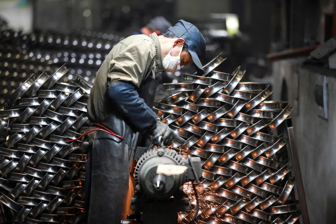 A worker processing stainless steel rings for bicycle for export at a factory in Hangzhou, in eastern China's Zhejiang province, on Feb 20, 2025
