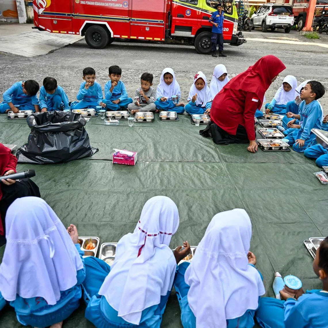 Kindergarten students eat food supplied by the Indonesian government's free meal program in Banda Aceh on April 23, 2026. (Photo by CHAIDEER MAHYUDDIN / AFP)
