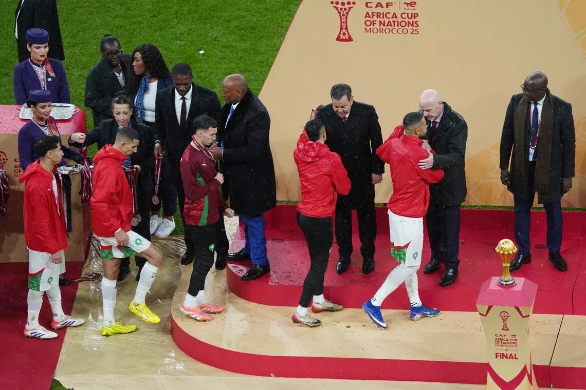 Soccer Football - CAF Africa Cup of Nations - Morocco 2025 - Final - Senegal v Morocco - Prince Moulay Abdellah Stadium, Rabat, Morocco - January 18, 2026 Morocco players are consoled on the stage by CAF president Patrice Motsepe and FIFA president Gianni Infantino as they collect their runners up medals REUTERS/Stringer
